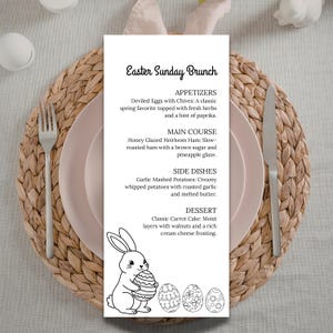 May include: An Easter Sunday Brunch menu card featuring a bunny illustration and Easter eggs. The menu lists appetizers, main course, side dishes, and dessert. The card is on a pink plate with cutlery and a woven placemat.