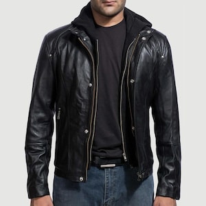 May include: Black leather jacket with a zip-up front, a hooded collar, and multiple pockets. The jacket has a classic biker style with a tailored fit. The model is wearing a black t-shirt and blue jeans.