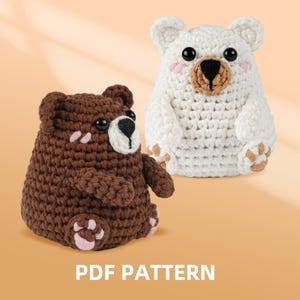 May include: Two crocheted bear figures, one brown and one white, with black eyes and pink accents. The brown bear has a light brown snout and paws, while the white bear has a tan snout and paws. The text "PDF PATTERN" is displayed at the bottom.