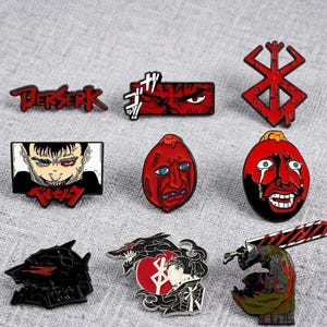 May include: A collection of nine enamel pins featuring imagery from the Berserk series. Designs include the red Berserk logo, a close-up eye, the Brand of Sacrifice, a character portrait, two crying faces, a black helmet, a circular emblem, and a warrior.