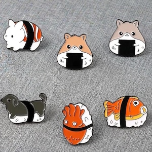 May include: A collection of six enamel pins featuring sushi-themed designs. The pins include a white bunny, hamsters, a dachshund, a squid, and a fish, all styled as sushi rolls. The pins have black, white, orange, and brown colors.