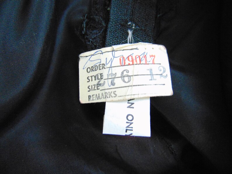 May include: A white tag with black text that reads "Order", "Style", "Size", and "Remarks". The tag has handwritten numbers on it: "09017", "276", and "12".
