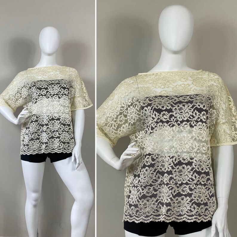 May include: A white lace top with a loose fit and short sleeves. The top is sheer and has a delicate floral pattern.