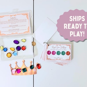 May include: A children's game with colorful gems, a crown cutout, and instruction cards. The gems are in a clear plastic container. The crown is gold with pink, green, and red gems. The game includes a card that says "Royal Gem Challenge".