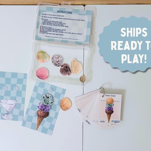 May include: An ice cream shop play set with various ice cream flavors, order tickets, and instructions. The set includes a variety of colorful ice cream scoops and cones, along with cards featuring ice cream sundae and cone illustrations. The set is ready to play.