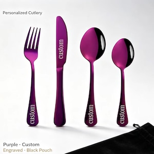 May include: A set of four purple metallic cutlery pieces including a fork, a knife, a large spoon, and a small spoon. Each piece features the word custom engraved on the handle or blade. A black fabric pouch is positioned in the lower right corner.