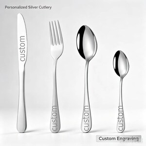 May include: A set of four pieces of silver-colored cutlery including a knife, a fork, a large spoon, and a small spoon. Each piece features the word custom engraved on the handle or blade. The text Personalized Silver Cutlery appears at the top.