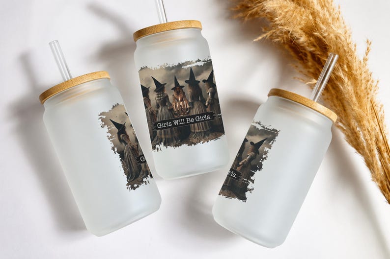 May include: Three frosted glass tumblers with bamboo lids and clear glass straws. Each tumbler features a graphic print of witches in pointed hats standing in a circle with the text Girls Will Be Girls printed in a black rectangular banner.