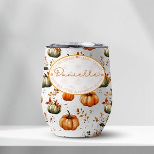 May include: A white tumbler with a fall-themed design featuring pumpkins, leaves, and the text "Autumn Breeze, Falling Leaves, Bonfires, Cider, & Pumpkins, Please." The name "Danielle" is also displayed. The tumbler has a silver lid.