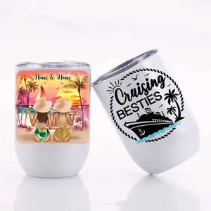 May include: Two women in swimsuits and sunglasses are standing on a beach with palm trees and a sunset in the background. The text "Cruising Besties" is on a white tumbler with a black ship and anchor.