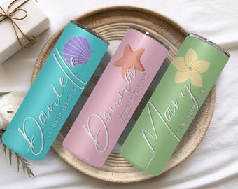 May include: Three cylindrical tumblers in teal, light pink, and light green. The teal tumbler features a purple seashell and the text Danielle ST. AUGUSTINE 2026. The pink one has a starfish and Donna GIRLS TRIP 2026. The green one has a flower and Mary FAMILY CRUISE 2026.