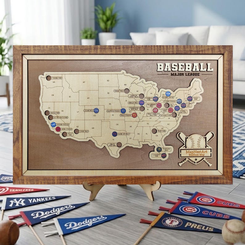 May include: A wooden baseball stadium map of the United States, with team markers. The map is framed in a light brown wood and includes the text "BASEBALL MAJOR LEAGUE". Several team pennants and a baseball are in the foreground.