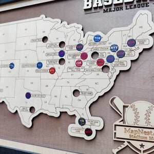 May include: A wooden map of the United States with baseball stadium markers. The map is light brown with stadium names and team logos. The words "BASEBALL MAJOR LEAGUE" are at the top.