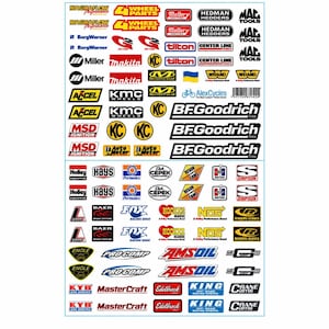 May include: A sticker sheet featuring a collection of various automotive brand logos and company names in multiple colors including red, yellow, blue, black, and white. The sheet contains numerous small decals with text such as Magnaflow, BFGoodrich, Holley, and others arranged in rows.