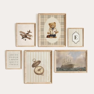 May include: A gallery wall set of six framed prints featuring a vintage biplane, a teddy bear in a jacket on a plaid background, the letter E, an alphabet chart, a brass compass, and a large sailing ship on the ocean under a cloudy sky.