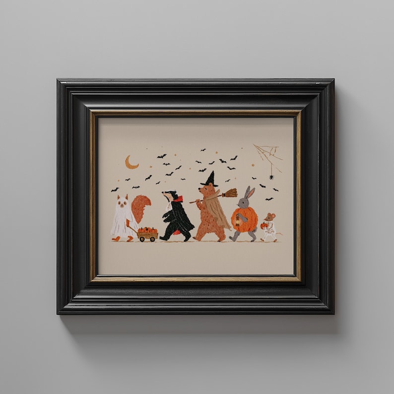 May include: A framed art print featuring a line of woodland animals in Halloween costumes, including a squirrel as a ghost, a badger as a vampire, a bear as a witch, a rabbit in a pumpkin suit, and a mouse, all under a sky with bats and a crescent moon.