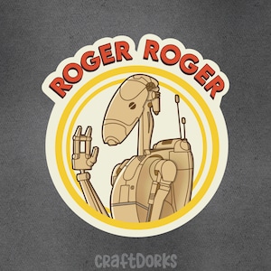 May include: A sticker featuring a cartoon droid with the text "ROGER ROGER" in a red, retro font. The droid is beige and has a raised hand. The sticker has a yellow border and the text "craftDORKS" at the bottom.