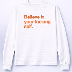 Könnte beinhalten: Weißes Langarmshirt mit dem orangefarbenen Text "Believe in your fucking self." Das Shirt hat einen Rundhalsausschnitt und lange Ärmel. Der Text ist mittig platziert.