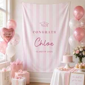 Może przedstawiać: Tło na zakończenie szkoły w pionowe jasnoróżowe i białe paski z ikoną czapki absolwenta, napisem CONGRATS, imieniem Chloe oraz napisem CLASS OF 2026. Scena zawiera różowe i białe balony, torebki prezentowe oraz tort.