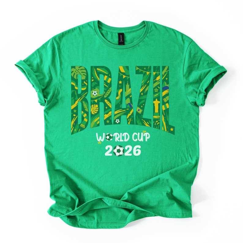 May include: A green t-shirt with the word "BRAZIL" in large, yellow, and green letters. The word is filled with various patterns and symbols. Below the word is "WORLD CUP 2026" with soccer ball graphics.