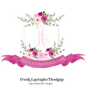May include: A pink and white floral monogram logo with the letter "H" in the center. The logo is surrounded by a pink ribbon with the text "Alexa's Monograms" and the text "Fresh Lavender Designs ©premade logo" below the ribbon.