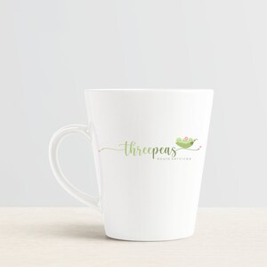 May include: White ceramic mug with a green peapod logo that says "threepeaS doula services".