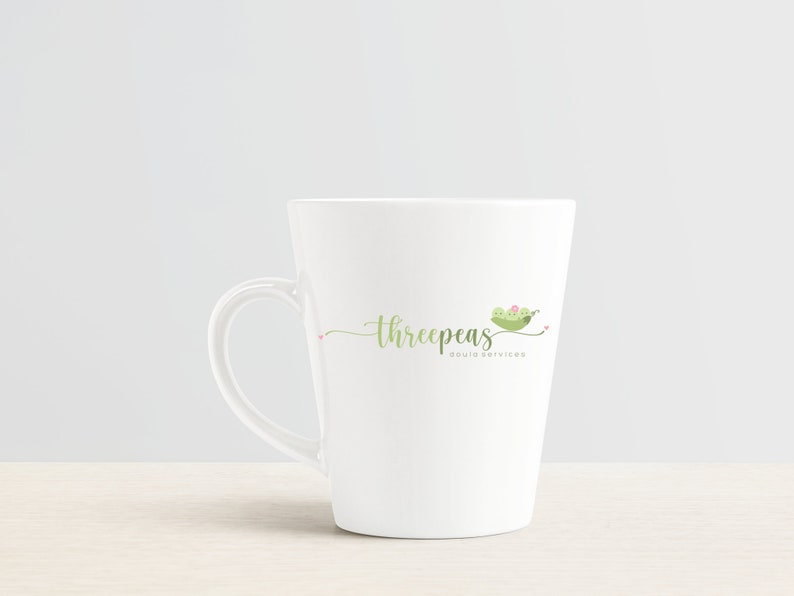 May include: White ceramic mug with a green peapod logo that says "threepeaS doula services".