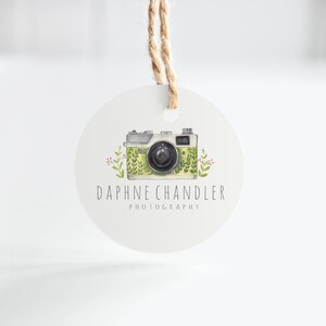 May include: A round white tag with a green and white camera illustration and the text "Daphne Chandler Photography".