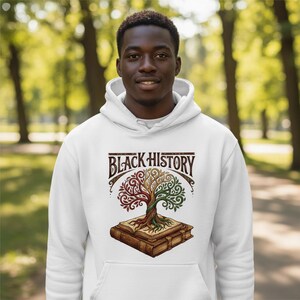 May include: White hoodie with a graphic design featuring the text "BLACK HISTORY" above a tree with red, green, and brown leaves, rooted in a book. The design is in a vintage style.