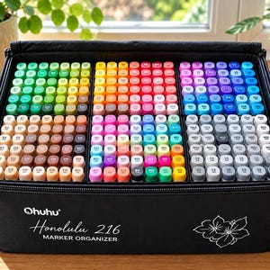 May include: A black Ohuhu Honolulu 216 marker organizer case containing a large collection of colorful markers arranged in six distinct rectangular sections. The front of the case features the white text Ohuhu Honolulu 216 MARKER ORGANIZER.