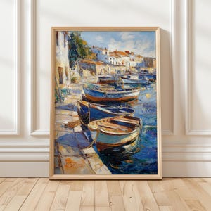May include: An oil painting in a light wood frame depicting a harbor scene with several small boats moored along a stone quay. The artwork features thick, textured brushstrokes in shades of blue, white, orange, and brown, capturing the sunlight reflecting on the water and the buildings in the background.