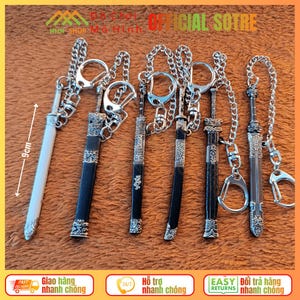 Può includere: Collezione di portachiavi a forma di spada in miniatura, ciascuno di circa 9 cm di lunghezza, con catene e portachiavi color argento. Le spade presentano disegni dettagliati, con dettagli neri e argentati. I portachiavi sono esposti su una superficie arancione.
