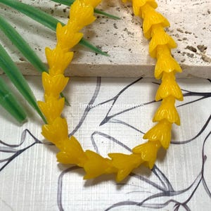 May include: A bright yellow beaded bracelet featuring a series of small, molded flower-shaped beads linked together in a continuous circular strand. The text "Yellow" appears in the upper left corner, and "TimelessTreasuresHub" is printed in the center.