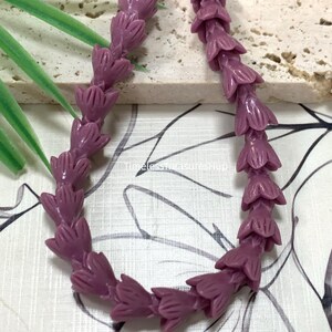 May include: A strand of deep purple beads shaped like small flower buds. The beads are arranged in a curved line. The text Deep Purple is visible at the top left, and the text TimelessTreasuresHup is visible in the center of the image.