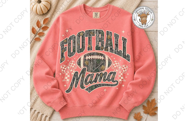 May include: A coral-colored crewneck sweatshirt featuring a graphic print with the text FOOTBALL MAMA in a camouflage pattern. The design includes a central football, two checkered bows, and small star accents. A circular logo with a highland cow is visible.