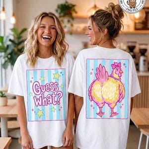 May include: Two white t-shirts with matching designs. One shirt has the text "Guess What?" in a pink and blue frame with stars. The other shirt features a cartoon chicken with a pink crown and necklace, set in a similar frame.