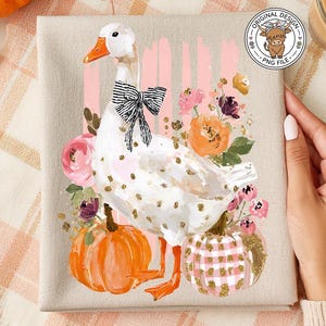 May include: A canvas print featuring a white goose with a black and white bow, surrounded by flowers and pumpkins. The goose has gold polka dots. The pumpkins are orange and pink. The background has pink stripes.