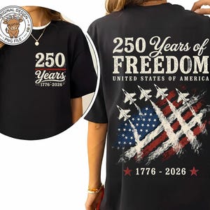 May include: A black t-shirt featuring a patriotic design. The front displays '250 Years 1776-2026'. The back features '250 Years of FREEDOM UNITED STATES OF AMERICA', a graphic of four fighter jets with smoke trails over an American flag, and '1776-2026'.
