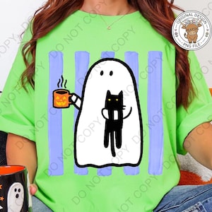 May include: A bright lime green t-shirt featuring a graphic of a white ghost holding an orange jack-o'-lantern mug and a black cat. The design is set against vertical light purple stripes. The shirt is worn with blue denim jeans.