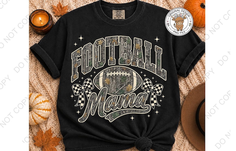 May include: A black short-sleeve t-shirt featuring a graphic print with the text "FOOTBALL Mama" in a camouflage pattern. The design includes a football, two checkered bows, and small star accents. The shirt has a crew neckline and a relaxed fit.