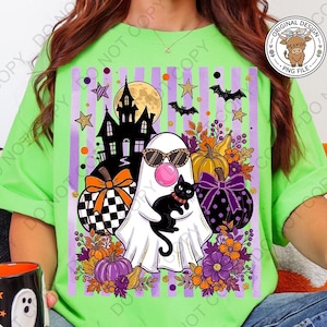 May include: A lime green t-shirt featuring a graphic print of a white ghost wearing leopard print sunglasses and blowing a pink bubble. The ghost holds a black cat, surrounded by a haunted house, pumpkins, bats, stars, and purple flowers.