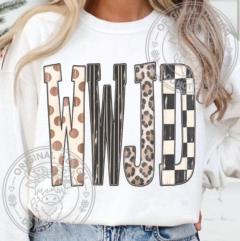 May include: A white long-sleeve sweatshirt featuring the letters WWJD printed on the front. Each letter has a distinct pattern: the Ws feature brown polka dots and black vertical stripes, the J has a leopard print, and the D has a black and white checkerboard pattern.