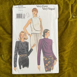 Pode incluir: Um padrão de costura vintage intitulado "Very Easy Very Vogue" com ilustrações de três roupas diferentes. O número do padrão é 9156 e o tamanho é 8-10-12. A capa apresenta um top branco, um top roxo e um top preto.