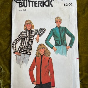 May include: A vintage Butterick sewing pattern, size 14, featuring illustrations of three jacket designs. The pattern cover displays the text "QUICK! BUTTERICK" and the price $2.00. The jackets are in black and white, teal, and red.