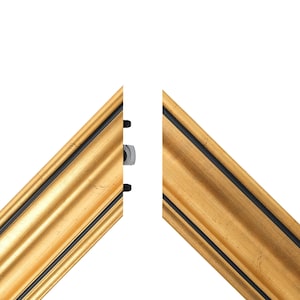 May include: Two sections of a gold picture frame with a black inner edge. The frame features a decorative, ridged design. A silver bolt and black fasteners are visible on the frame's edge, suggesting assembly or joining.