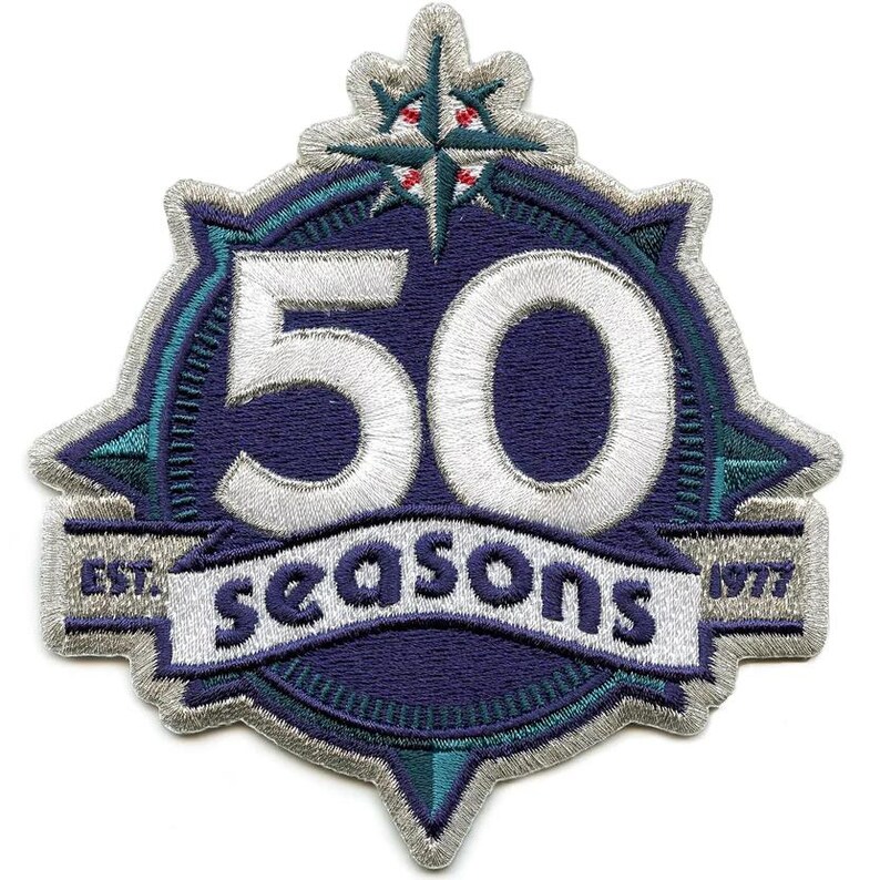 May include: Embroidered patch with a navy blue background and white stitching. The patch features the number 