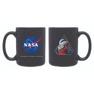 May include: Black ceramic mug featuring the NASA logo on one side and a space-themed design on the other. The NASA logo includes a blue sphere, white text, and a red swoosh. The other side has a triangular design with a moon and planet.