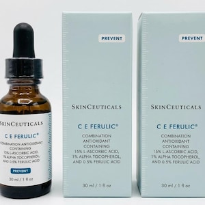 May include: A brown glass bottle with a black dropper and two light blue boxes. The bottle and boxes display the text "SkinCeuticals C E Ferulic" and ingredient information. The bottle contains 30 ml / 1 fl oz.