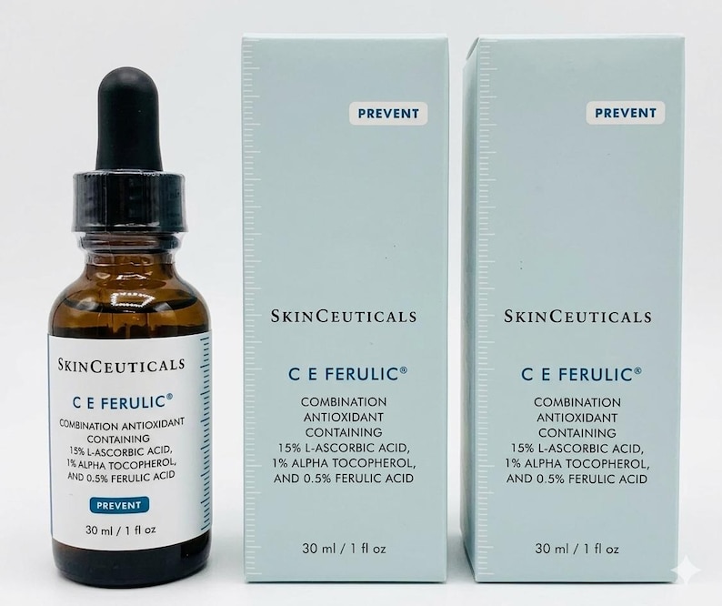 May include: A brown glass bottle with a black dropper and two light blue boxes. The bottle and boxes display the text "SkinCeuticals C E Ferulic" and ingredient information. The bottle contains 30 ml / 1 fl oz.