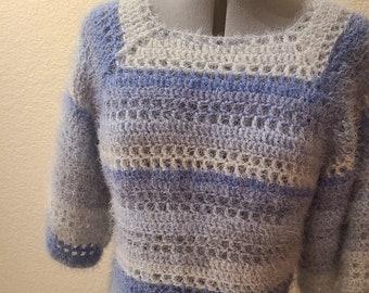 May include: A blue and white striped crocheted sweater with a fuzzy texture. The sweater has a scoop neck and 3/4 sleeves.